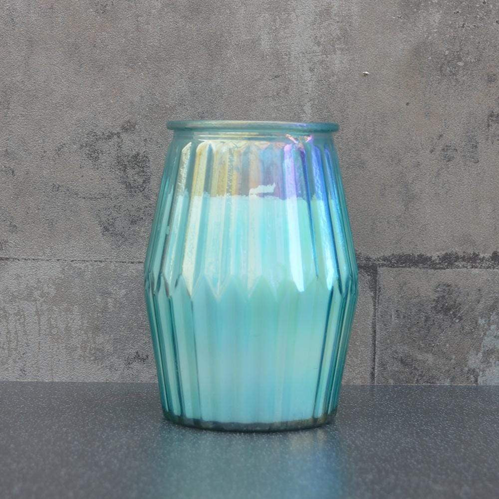 White cotton candle in blue ridged glass pot