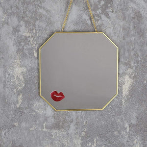 Gold hanging mirror with lipstick print
