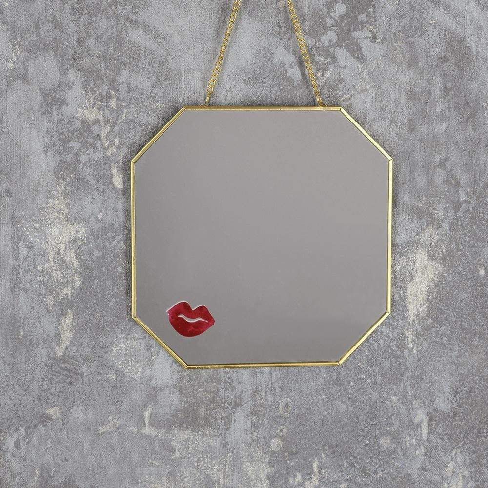 Gold hanging mirror with lipstick print